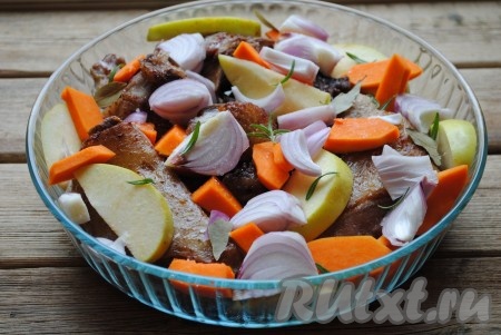 Обжаренное мясо выложить в жаропрочную форму, добавить нарезанную кубиками очищенную тыкву, дольки яблок и крупно нарезанный очищенный лук. Выложить лавровый лист и розмарин, если нужно, можно добавить ещё немного соли и специй.
