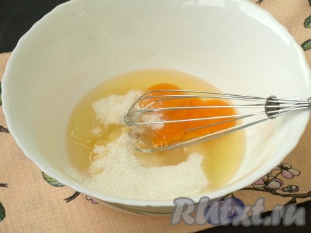 Чернослив сразу нарезать кубиками, сложить в небольшую ёмкость и залить ложкой коньяка, перемешать. Дальше заняться тестом: в миску разбить 2 яйца, добавить сахар и взбить венчиком.