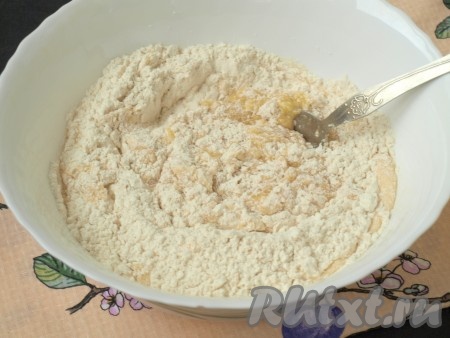 В получившееся тесто просеять муку и налить половину кефира, перемешать ложкой.
