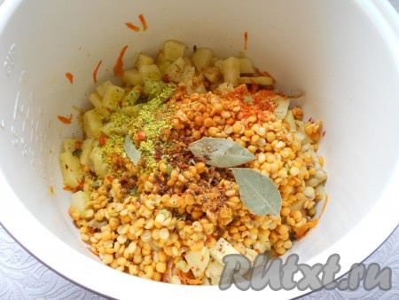 Добавить к обжаренным мясу и овощам нарезанный кубиками картофель, всыпать промытый горох, специи, соль, приправу для супа и шафран. Также добавить лавровый лист.
