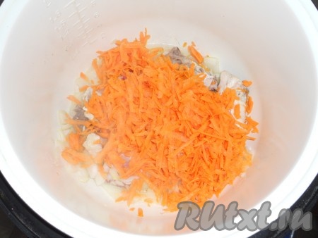 Также выложить в чашу мультиварки натертую на крупной терке морковь, всё перемешать, готовить до окончания программы, периодически перемешивая.
