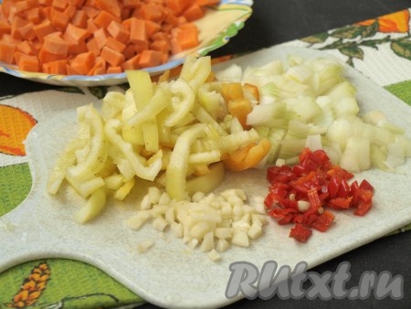 Кубиками нарезать морковь и лук, болгарский перец - соломкой, чеснок и острый перец - мелко. Количество острого перца берите на свой вкус. Если не любите острые блюда, то достаточно будет 1 см острого перца.
