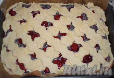 Оставшуюся часть теста тонко раскатать, нарезать из него полоски, а затем выложить на пирог в виде сеточки.