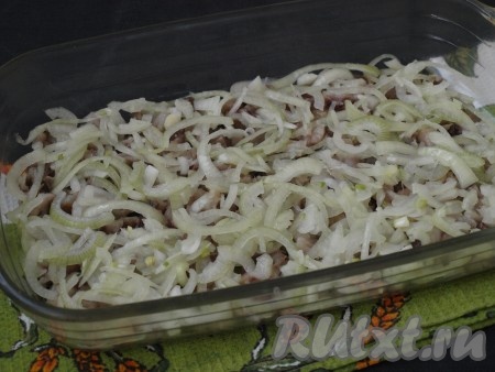 Очистить лук, нарезать его полукольцами, сложить в глубокую тарелочку, добавить по щепотке сахара и соли, влить уксус. Помять лук руками, отжать от лишней жидкости, затем выложить поверх сельди.