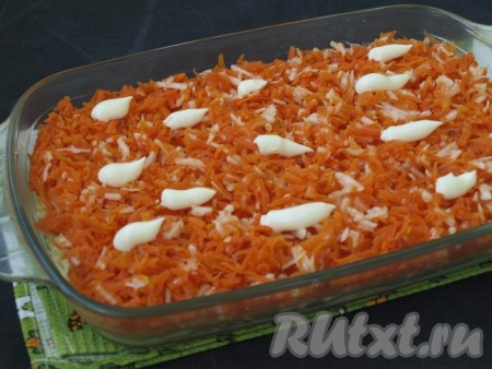 В ёмкость с натёртыми яблоками натереть на крупной тёрке очищенную варёную морковь. Перемешать яблоки с морковью, а затем равномерно выложить поверх слоя картофеля, смазать майонезом.
