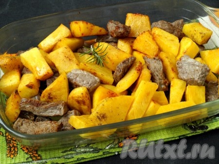 Выложить мясо с тыквой в форму для запекания, сверху положить веточку розмарина, налить в форму горячую воду. Накрыть форму фольгой и поставить в разогретую до 180 градусов духовку.
