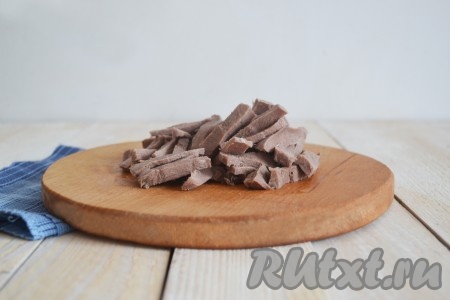 В подсоленной воде отварить свиной язык в течение 1,5 часов (говяжий язык варить 2-2,5 часа). Вынуть и сразу же опустить на 3 минуты в холодную воду. Очистить от пленки, а когда полностью остынет - нарезать соломкой.
