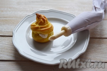 Наполнить кондитерский пакет с тонкой длинной насадкой творожным кремом и плотно наполнить каждый юмбрик.
