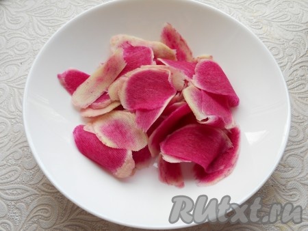 Нарезать редьку с помощью овощечистки на тонкие слайсы.