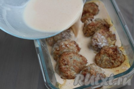 Перекладываем обжаренные тефтели в жаропрочную форму, заливаем подготовленной томатно-сметанной подливкой.
