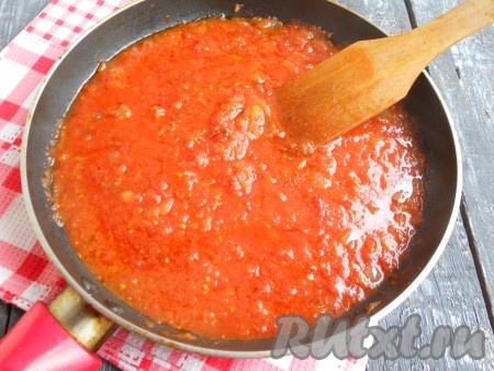 Сковороду с жиром и луком поместить на средний огонь. Обжарить лук, иногда помешивая, до легкой золотистости (жир растопится). Добавить в сковороду томатную пасту и густой домашний томат (или перекрученные помидоры), всыпать сахар и немного посолить. Кипятить томатную заправку около 4-5 минут на медленном огне.