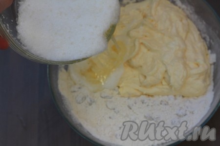 Добавить в масляную массу оставшиеся взбитые белки и смесь муки, крахмала, разрыхлителя и изюма, хорошо перемешать. Тесто получится достаточно густым.
