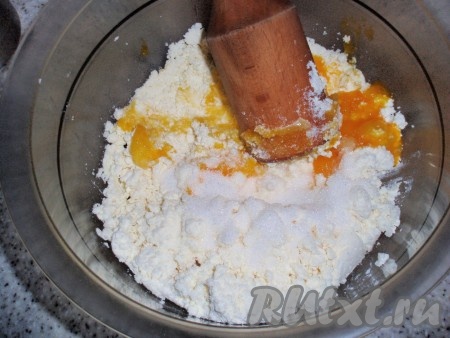 Творог тщательно размять или пропустить через мясорубку. Яйца разделить на белки и желтки. К творогу добавить яичные желтки, сахар и ванильный сахар, все перемешать.
