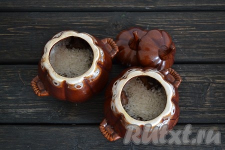 Рис промыть холодной водой несколько раз. Затем хорошо сцедить воду и разложить по горшочкам.
