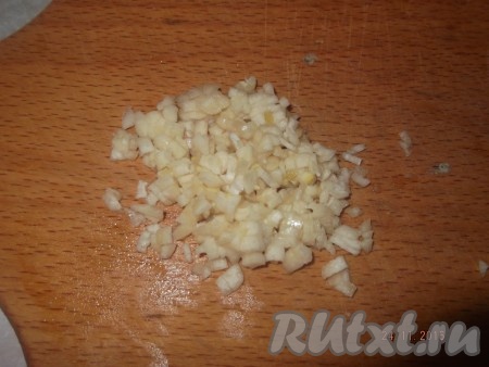 Поливаем горячим маслом нашу морковь, сверху посыпаем очищенным мелко нарезанным чесноком, перемешиваем.