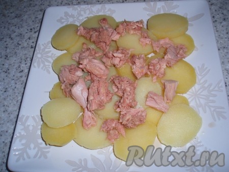 Сверху выложить кусочки консервированного тунца.