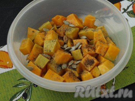 Очищенную тыкву нарезать на средние кубиками, сложить в миску, добавить соль, специи, по желанию, всыпать тыквенные семечки, перемешать.