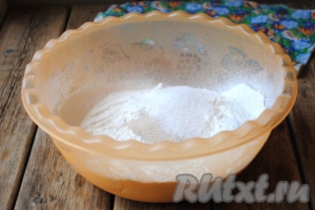 Добавить дрожжи, сахар и соль в миску с мукой, всё перемешать. 
