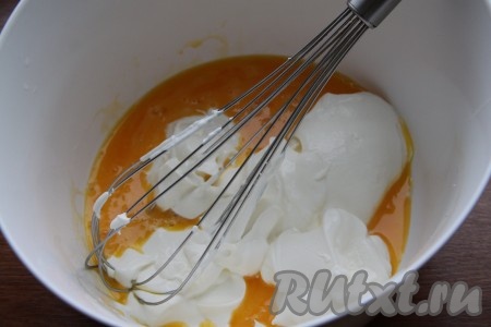 Яйца разделить на белки и желтки. Желтки смешать со сметаной.
