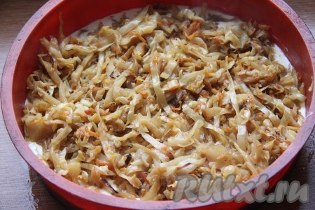 Получившееся тесто разделить на две части. Одну часть теста вылить в форму для выпечки (если форма для выпечки не силиконовая, её можно застелить бумагой для выпечки или смазать маслом), выложить начинку. Для приготовления капустной начинки&nbsp; натёртую на крупной тёрке морковь обжарить в сковороде или казанке на растительном масле в течение нескольких минут, затем выложить нашинкованную капусту, перемешать, посолить, налить немного воды и тушить на небольшом огне под закрытой крышкой 15 минут. Затем добавить столовую ложку томатной пасты, сахар и продолжить тушить,&nbsp;помешивая, с открытой крышкой до выпаривания лишней жидкости.