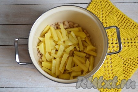 С отваренной фасоли слить воду и выложить к ней картофель. 