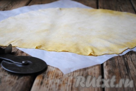 Рабочую поверхность присыпать мукой и раскатать каждую часть теста в тонкий пласт толщиной не более 1-1,5 миллиметров. Готовый пласт теста выложить на пергамент и оставить на 15 минут, чтобы он немного подсох.&nbsp;
