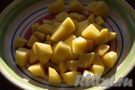 В бульон с мясом выложить сварившиеся нут и фасоль, добавить немного воды, в которой варились нут с фасолью. Очищенный картофель нарезать кубиками и выложить в суп, поставить на огонь и варить на небольшом огне до готовности картошки.
