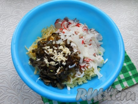 Капусту морскую порубить немного и добавить в салат. Сюда же добавить измельченный чеснок. Репчатый лук нарезать тонкими полукольцами, залить на 5 минут кипятком, а затем отжать и тоже добавить в салат.
