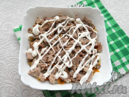 Отварную говядину нарезать кусочками и выложить следующим слоем + майонез.
