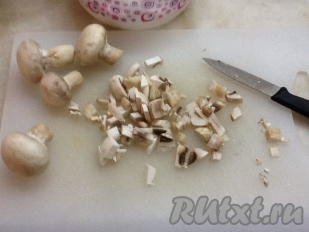 Нарезать мелко шампиньоны и добавить к луку, помешивая для равномерного обжаривания. 