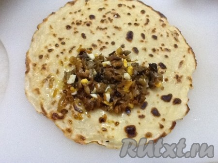 На каждый блин выкладывать немного грибной начинки и сворачивать его конвертиком.