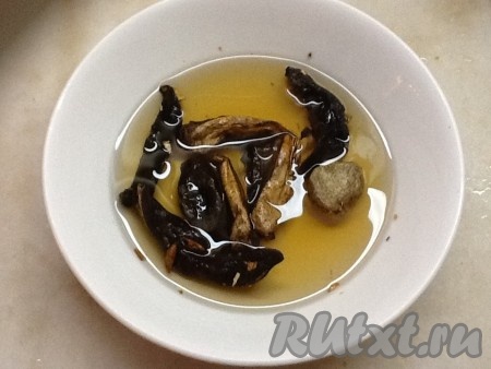 Замочить сухие грибы в кипяченой воде и дать им настояться.
