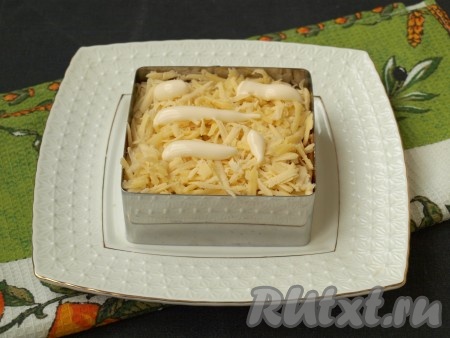 Натереть на тёрке твёрдый сыр, выложить его сверху моркови. Смазать сыр майонезом.
