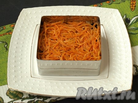 Нарезать корейскую морковку на достаточно короткие полоски, выложить следующим слоем, немного смазать майонезом.