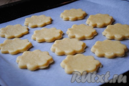 Выложить вырезанные молочные коржики на противень, застеленный пергаментной бумагой.