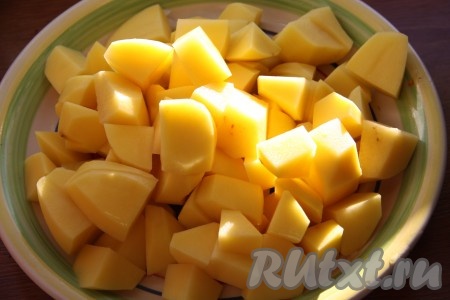 По истечении времени к овощам и свинине добавить нарезанный кубиками очищенный картофель, соль и специи. Без добавления воды продолжать готовить, иногда помешивая, до полуготовности картошки (10 минут). Картофель должен получиться со слегка поджаренной корочкой.