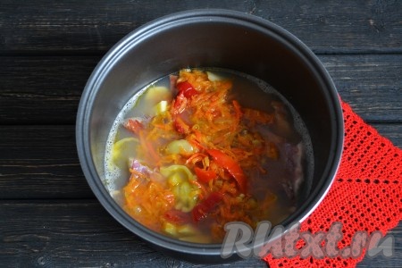 Через 15 минут выложить в чашу ранее обжаренные овощи. Добавить по вкусу соль. Нужно помнить, что копчености содержат в себе определенно количество соли, поэтому лучше не досолить суп, иначе он настоится и будет пересолен. Включить снова функцию "Суп" на 5 минут.