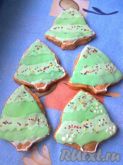 Пряники в форме елочки с зеленой глазурью украсила еще и цветной посыпкой,
