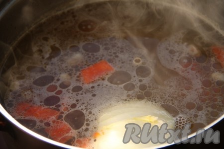 В куриный бульон или воду выложить фасоль, довести до кипения и варить на небольшом огне до готовности фасоли. Я варила суп с белой фасолью, поэтому предварительно её не замачивала, если готовите с красной фасолью, то её лучше предварительно замочить на 5-7 часов. Время варки фасоли зависит от её сорта, я варила минут 30. В середине приготовления добавить целую луковицу и крупно нарезанную морковь.