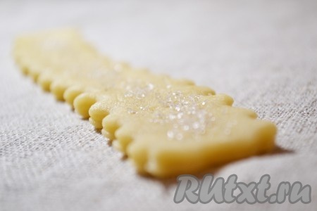 Сверху каждое творожное печенье посыпать сахаром, выложить на пергамент (на пергаменте не должно быть сахара, иначе он будет гореть, появится неприятный запах) и поставить в разогретую духовку. Выпекать 15-20 минут при температуре 180 градусов.
