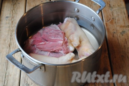 Мякоть говядины и свиные ножки вымыть, выложить в кастрюлю и залить чистой водой так, чтобы она полностью покрывала мясо, отправить кастрюлю на огонь. Когда вода закипит, на поверхности появится сероватая пена, эту воду надо будет вылить. Мясо ещё раз хорошо вымыть, снова выложить в кастрюлю, залить 3 литрами чистой воды.&nbsp;