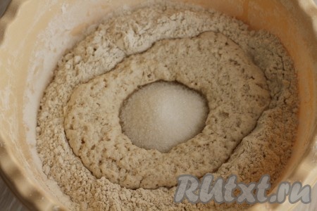 Сделать углубление в середине мучной смеси и влить туда подошедшие дрожжи, добавить оставшийся сахар.
