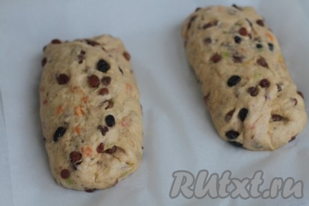 Снова придать тесту прямоугольную форму, отступить 1/3 от края пласта и сделать в тесте углубление, проведя борозду ребром ладони. Сложить тесто по этому углублению, то есть большую часть теста складываем до углубления края теста, немного формируем и округляем. Теперь на противень, застеленный 3 листами пергаментной бумаги, перенести штоллен, накрыть пленкой и оставить его на 30 минут на расстойку.