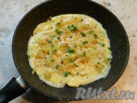 Прикрыть сковороду крышкой и готовить омлет с картофелем на слабом огне около 5 минут, затем выключить огонь. Оставить омлет под закрытой крышкой еще минуты на 3-4, после чего посыпать зеленью, паприкой и молотым чёрным перцем.
