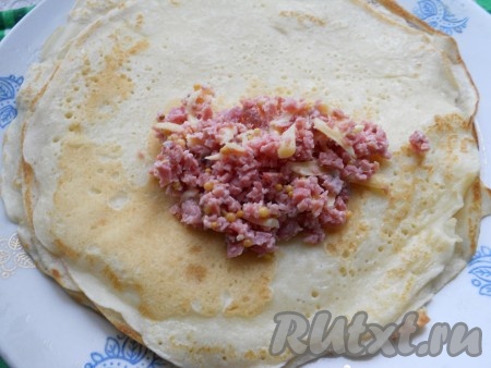 На каждый блинчик выкладывать по 1-1,5 столовых ложки колбасной начинки.
