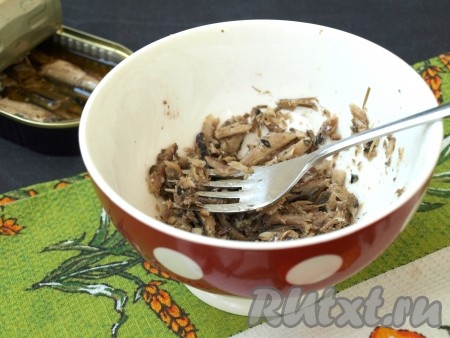 Шпроты переложить в пиалу без масла, размять вилкой.
