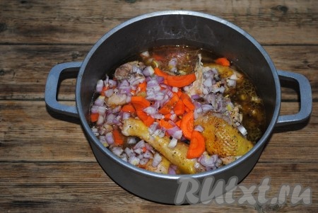 Всыпать соль, чёрный молотый перец, приправу к мясу и выложить лавровый лист. Влить воду. Отправить казан на плиту и довести до кипения, убавить огонь, накрыть крышкой и тушить кусочки курочки с луком и морковью на медленном огне до готовности мяса. 