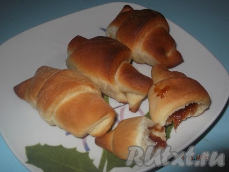 Выкладываем дрожжевые рогалики с повидлом на противень, смазанный маслом, и оставляем на 20 минут в тепле. Затем ставим в разогретую до 180 градусов духовку и выпекаем 20 минут. Вкусные рогалики готовы.