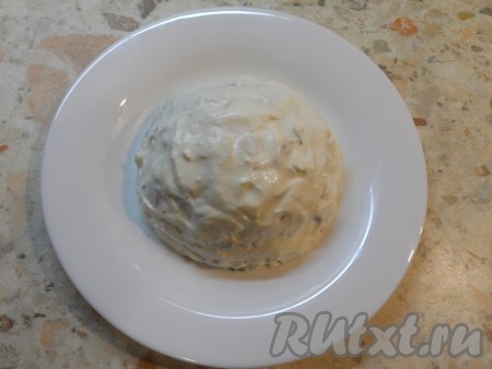 На тарелку выложить салат в виде полушара, смазать толстым слоем сметаны.