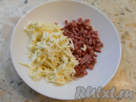 К колбасе, нарезанной маленькими кубиками, добавить натертый на крупной терке плавленный сырок.